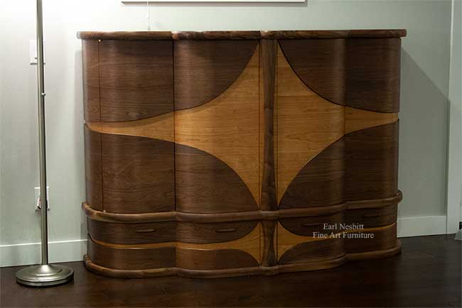 art deco bar cabinet emphasizing curved design from one side with all doors and drawers closed